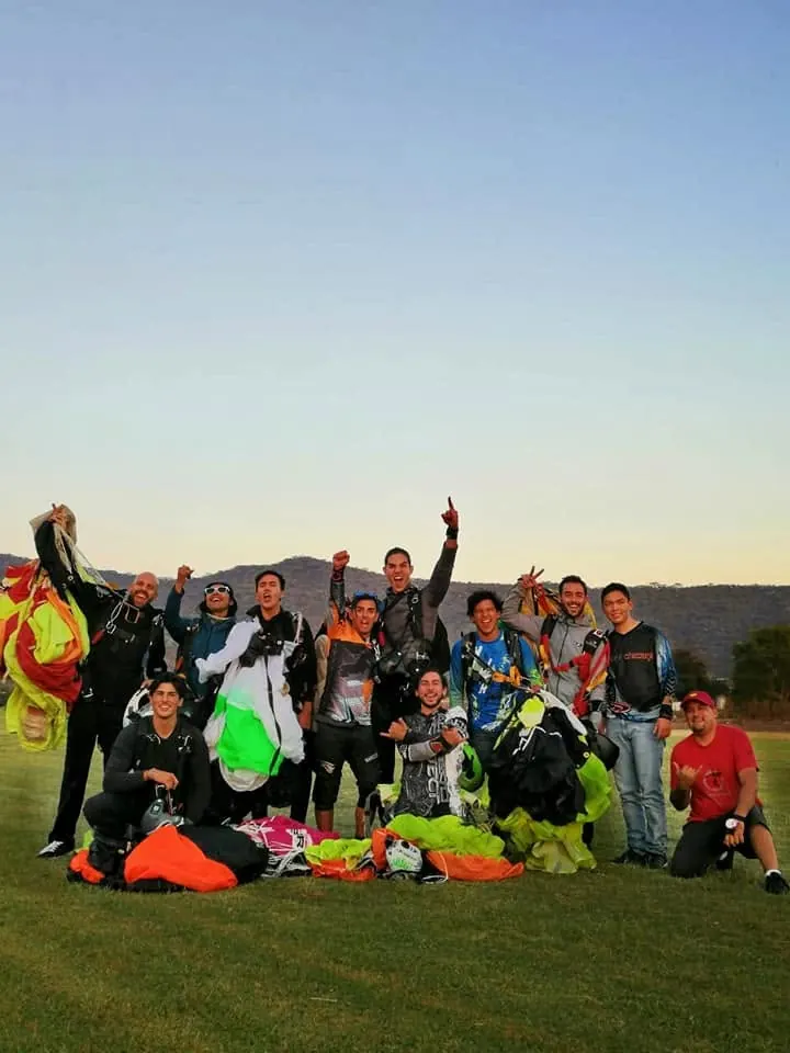Jumpers celebrating together at sunset on the landing area